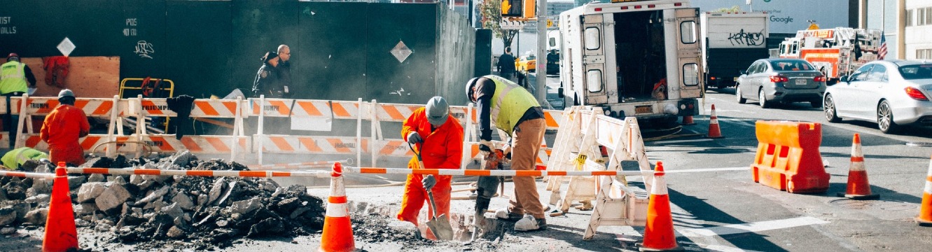 Deux employés de chantier travaillent dans une rue