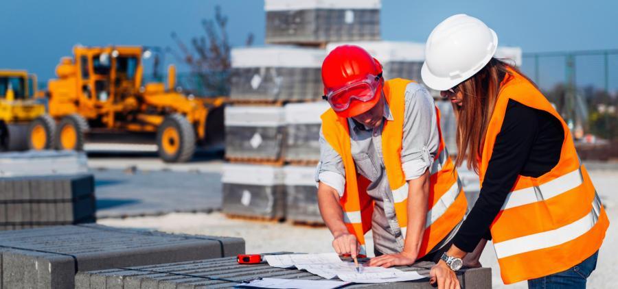 Deux ouvriers élaborent un plan de chantier